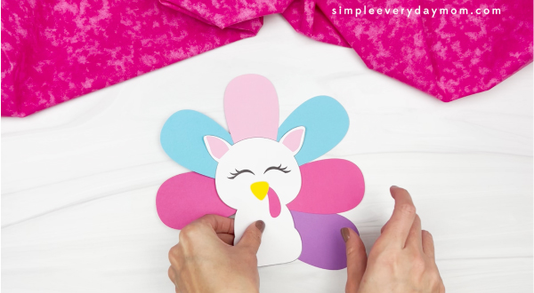 hand gluing feather to unicorn turkey in disguise craft