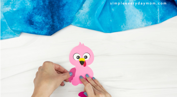 hands gluing wing to flamingo turkey in disguise craft