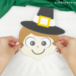 hand gluing head to handprint pilgrim collar