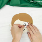 hand gluing eye to handprint pilgrim craft