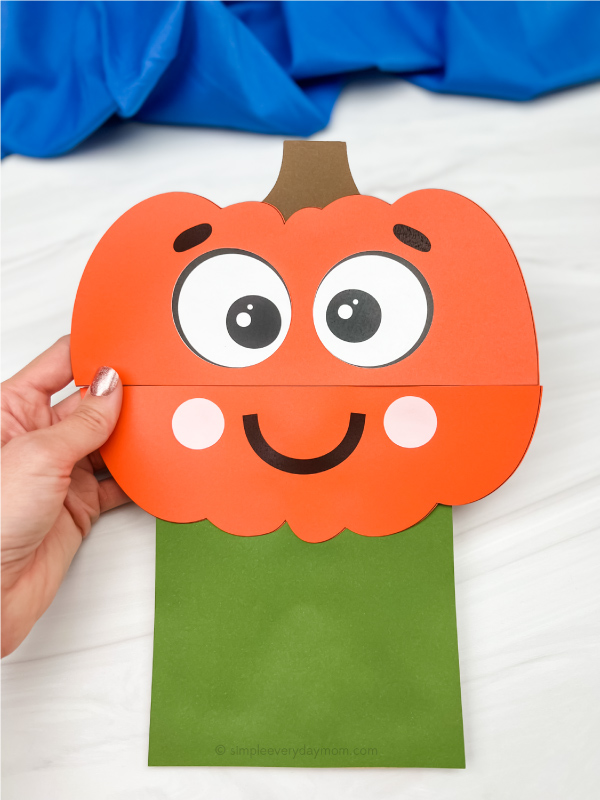 hand holding pumpkin paper bag craft