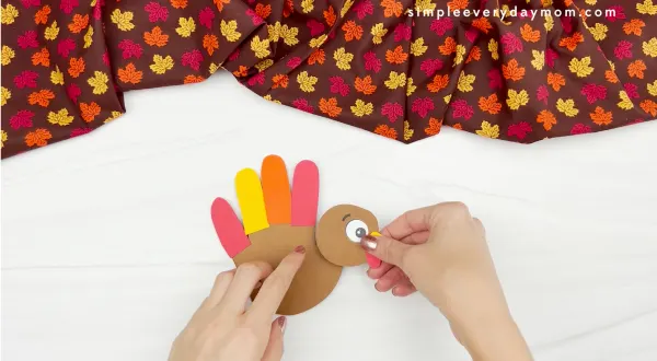 hand gluing head to turkey handprint card craft