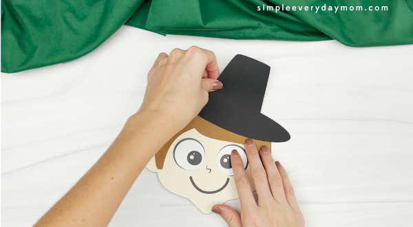 hand gluing hat to handprint pilgrim craft