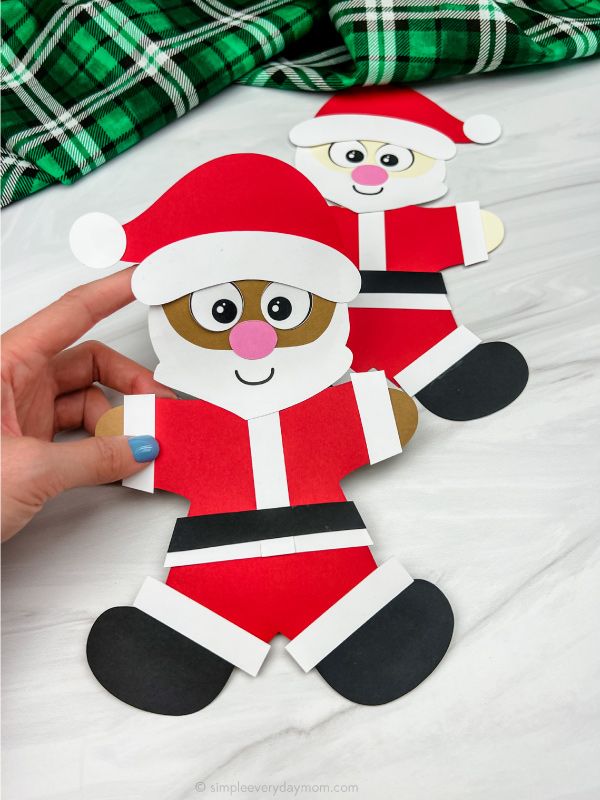 hand holding Santa disguise a gingerbread man craft with a 2nd one in the background