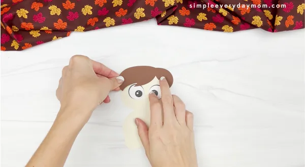 hands gluing hair to disguise a turkey craft