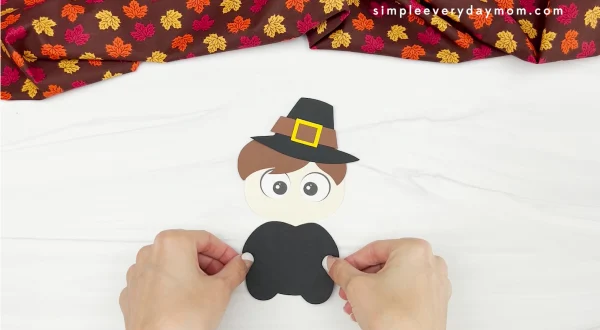 hands gluing clothes to disguise a turkey craft