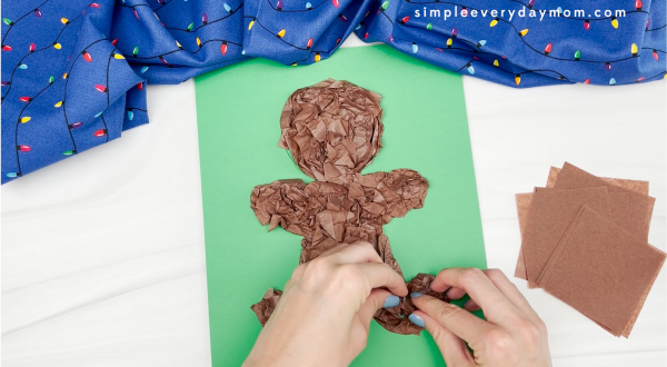 hands gluing brown tissue paper to gingerbread man template