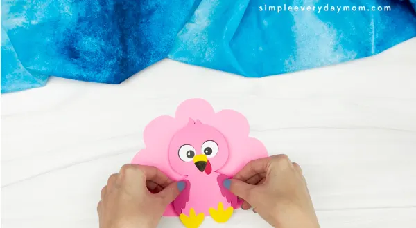hands gluing body to flamingo turkey in disguise craft