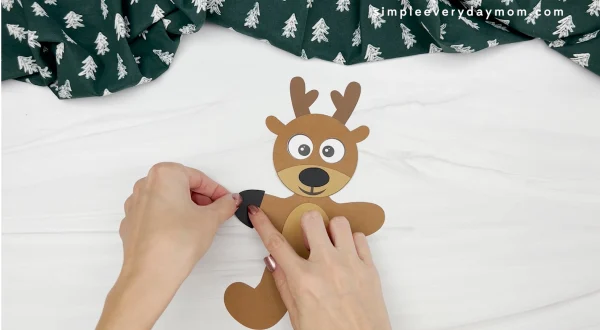 hands gluing hoof to reindeer gingerbread man disguise craft