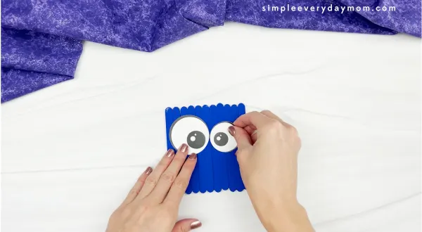 hand gluing eye to monster popsicle stick craft