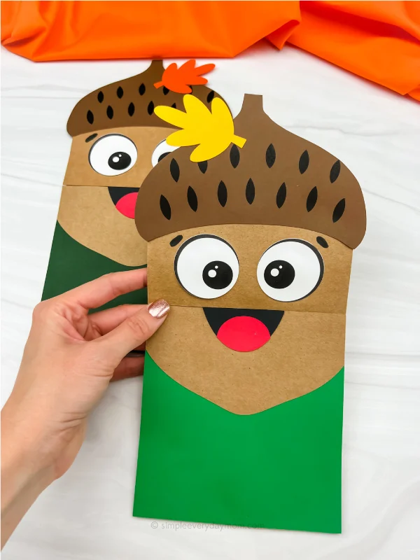 hand holding paper bag acorn craft with another one in the background