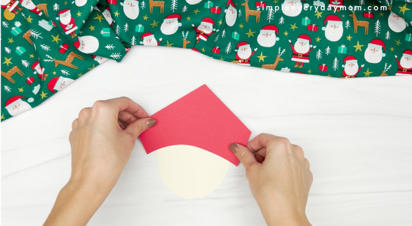 hand gluing red paper to handprint elf on the shelf craft