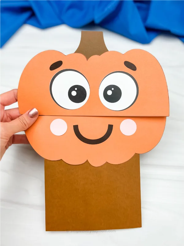 hand holding pumpkin paper bag craft