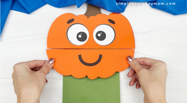 hand gluing lower pumpkin to paper bag pumpkin craft