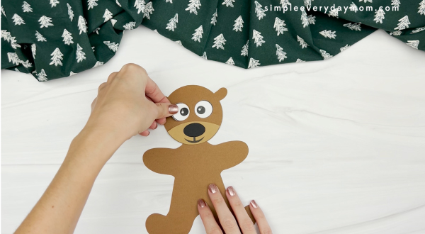 hands gluing eye to reindeer gingerbread man disguise craft