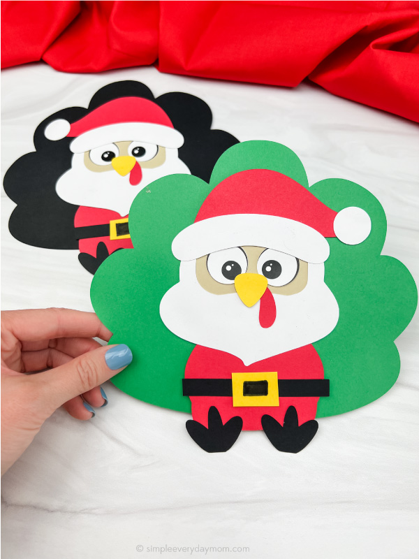 hand holding Santa turkey disguise craft with a second one in the background