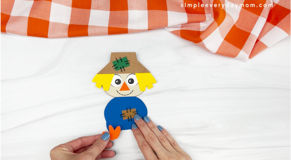 hands gluing feet to scarecrow turkey disguise craft