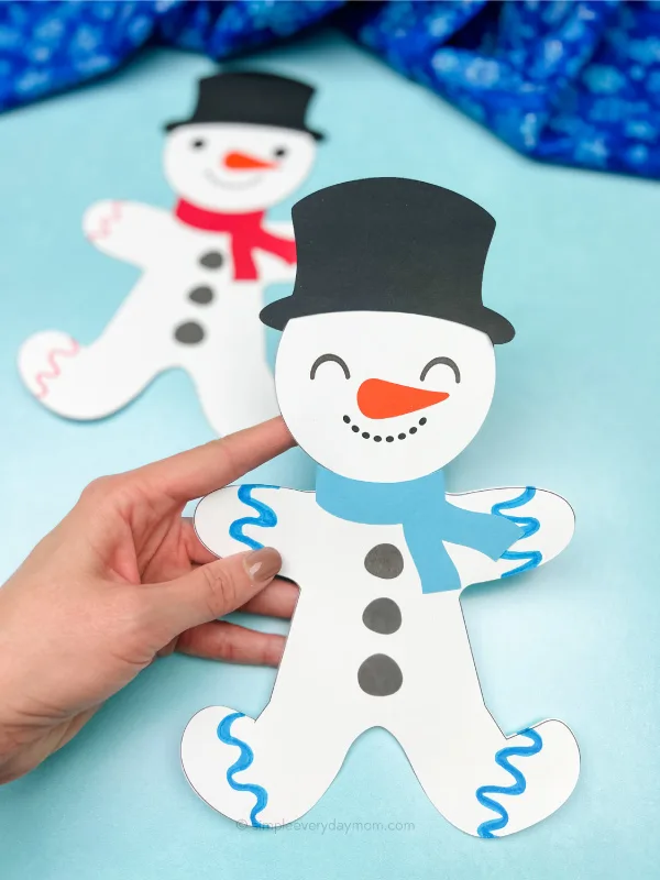 hand holding snowman gingerbread man disguise craft with another one in the background