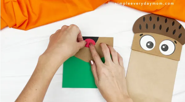 hand gluing tongue to paper bag acorn craft