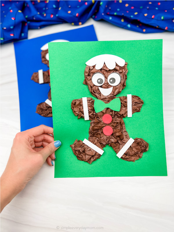 hand holding tissue paper gingerbread man craft with a 2nd one in the background