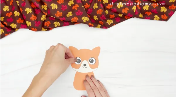 hand gluing eye to turkey in disguise cat craft
