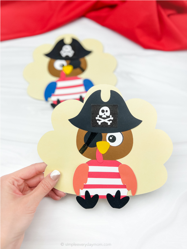 hand holding pirate turkey disguise craft with another on in the background