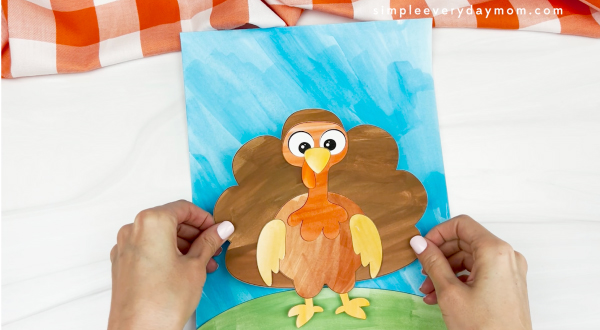 hands gluing watercolor turkey to background paper