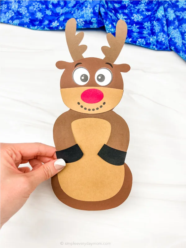 hand holding reindeer disguised as a snowman craft