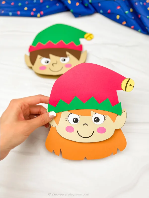 hand holding girl elf Christmas card craft with a boy one in the background