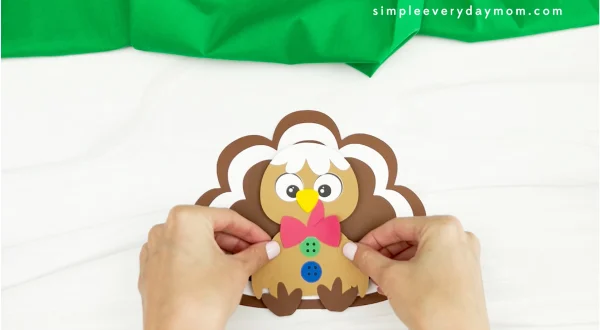 hands gluing body to gingerbread turkey disguise craft