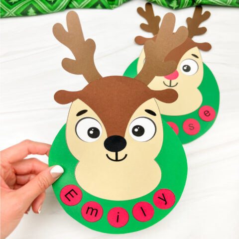 hand holding reindeer name craft with a second one in the background