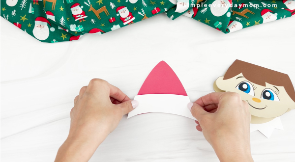 hands gluing santa hat together