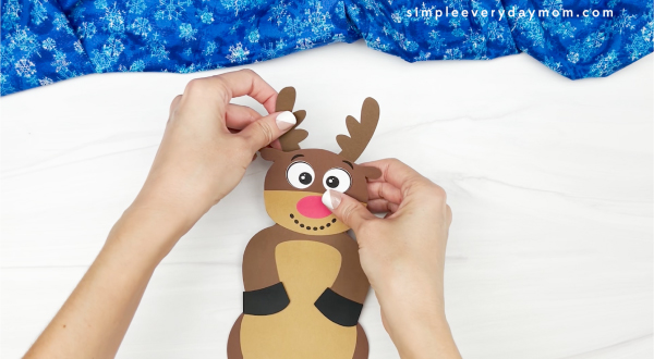 hands gluing antler onto reindeer snowman disguise craft