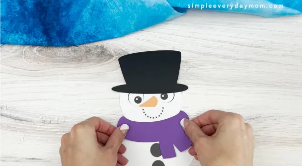hands gluing scarf to snowman card craft