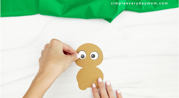 hands gluing eye to gingerbread turkey disguise craft