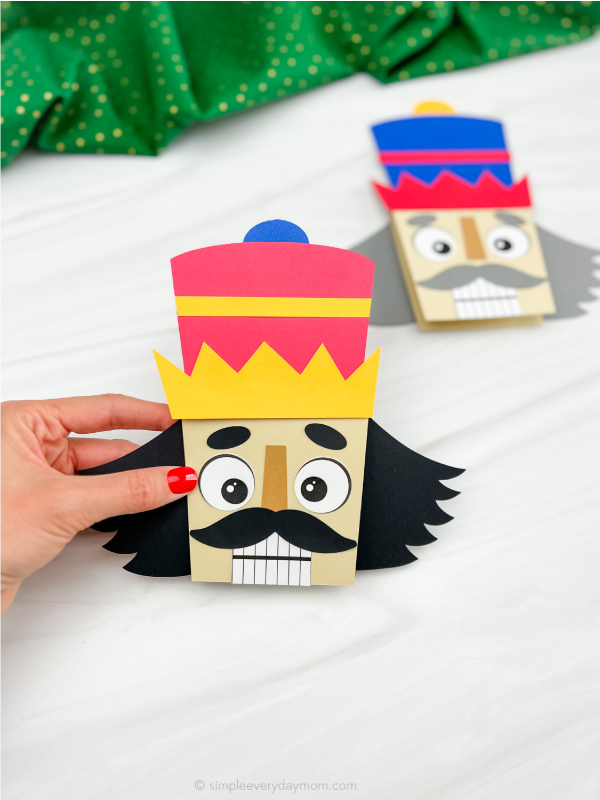hand holding nutcracker card craft with a second one in the background
