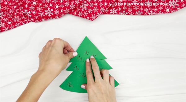 hand gluing tree top onto Christmas tree card craft