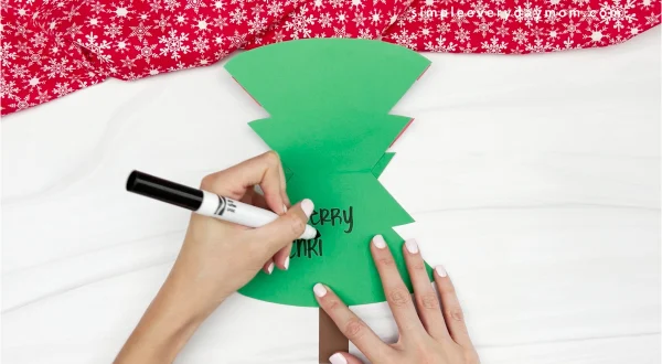 hand writing message inside Christmas tree card craft