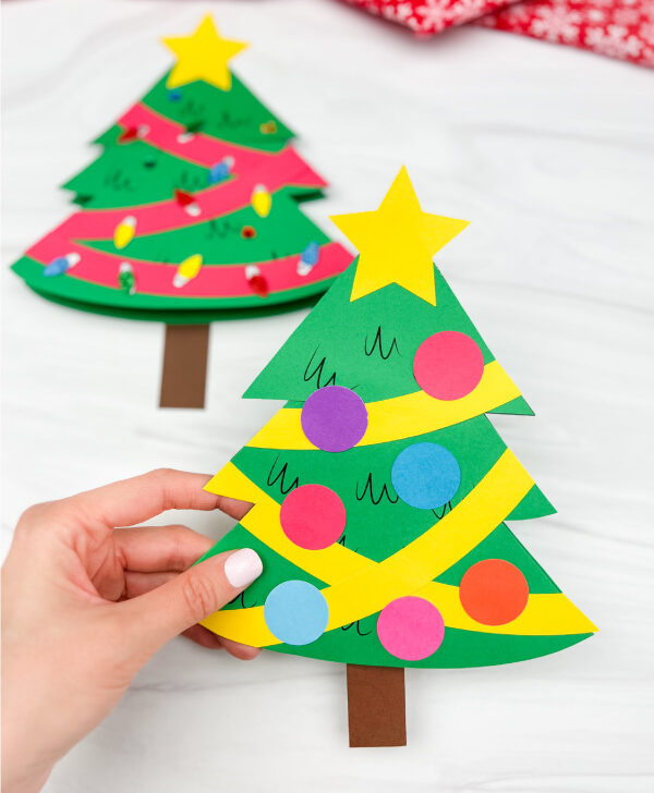 hand holding Christmas tree card craft with a second one in the background