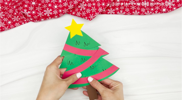 hand gluing trunk onto Christmas tree card craft