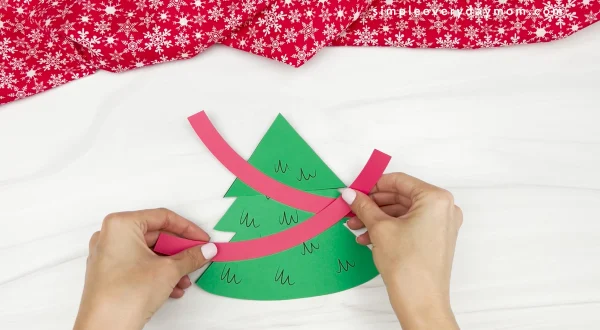 hand gluing decorations onto Christmas tree card craft