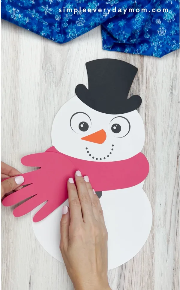 hands gluing handprint to handprint snowman craft