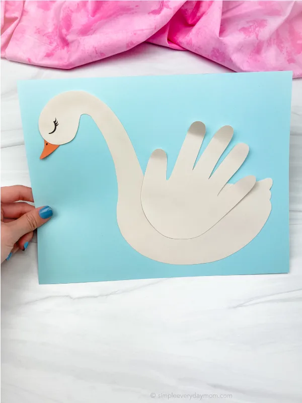 hand holding swan handprint craft
