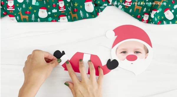 hands glueing mittens onto Santa photo craft