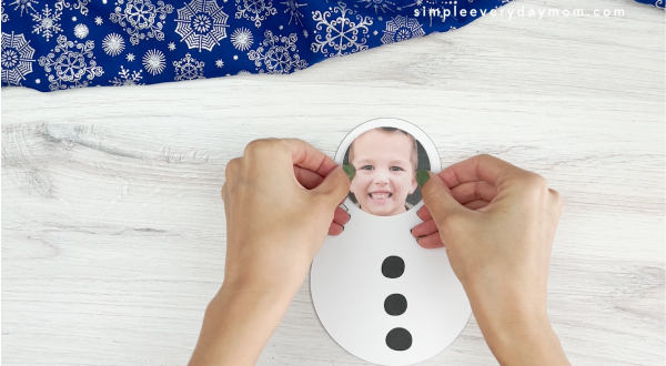 placing cut out image of face onto snowman photo craft