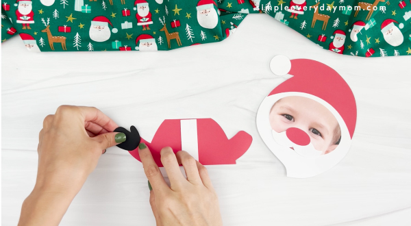 hands placing Santa's black mittens onto hand of Santa photo craft