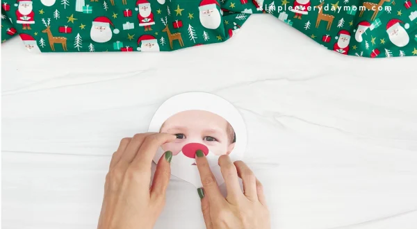 hands placing nose onto face for Santa photo craft