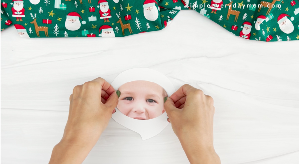 hands placing beard cutout onto face for Santa photo craft