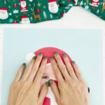 hands glueing Santa hat onto Santa photo craft