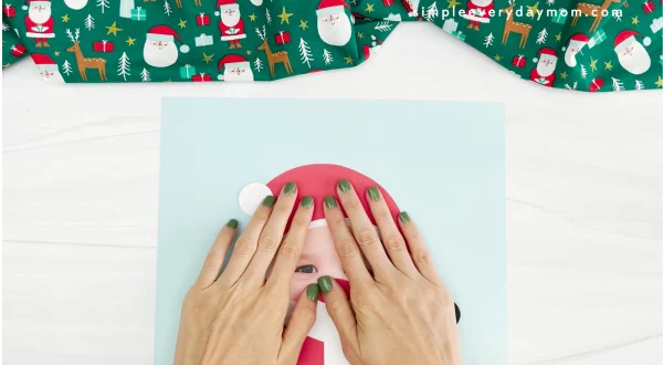 hands glueing Santa hat onto Santa photo craft